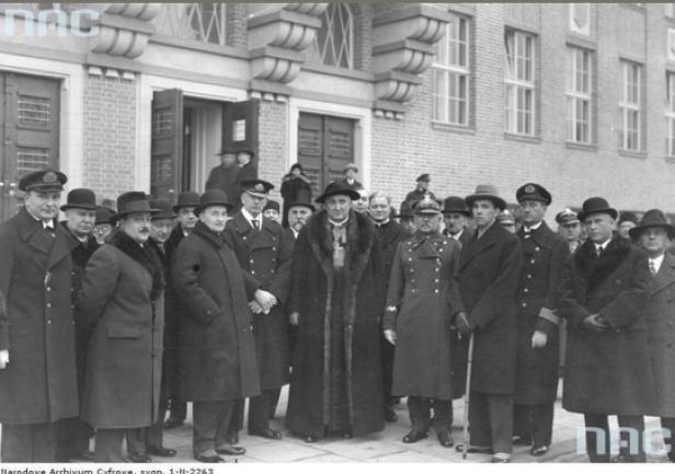 Uroczyste otwarcie i poświęcenie nowego gmachu Państwowej Szkoły Morskiej w Gdyni, 8 grudnia 1930 roku. Na zdjęciu m.in. pierwszy z lewej dyrektor PSM Adam Mohuczy, obok minister przemysłu i handlu Józef Kożuchowski, w środku biskup chełmiński Stanisław Okoniewski pomiędzy dowódcą Floty kmdr. Józefem Unrugiem i gen. Mariuszem Zaruskim, drugi z prawej inż. Antoni Garnuszewski. Fotografia ze zbiorów Narodowego Archiwum Cyfrowego.